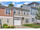 A colorful townhouse with a one car garage and a well-maintained lawn at 127 Deacon Ridge St, Wake Forest, NC 27587