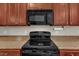 Close up of modern black appliances and dark wood cabinetry in the kitchen at 127 Deacon Ridge St, Wake Forest, NC 27587