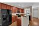Cozy kitchen with wood cabinets, granite countertops, black appliances, and wood floor at 127 Deacon Ridge St, Wake Forest, NC 27587