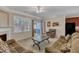 A cozy living room with a fireplace, ceiling fan, and backyard view at 127 Deacon Ridge St, Wake Forest, NC 27587