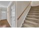 Carpeted staircase with wood railing and a view of the entryway at 127 Deacon Ridge St, Wake Forest, NC 27587