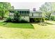 Charming two-story home featuring a screened-in porch, lush greenery, and a well-maintained lawn at 1706 Carthage St, Sanford, NC 27330