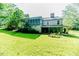 Expansive backyard featuring a screened-in porch, large trees, and a lush green lawn, perfect for outdoor enjoyment at 1706 Carthage St, Sanford, NC 27330