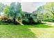 Back view of a home, showcasing a cozy screened porch and a beautiful, expansive yard filled with mature trees at 1706 Carthage St, Sanford, NC 27330