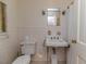 Bathroom featuring white tile, vintage sink, and toilet at 1706 Carthage St, Sanford, NC 27330