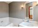 Classic bathroom with white tiles, patterned wallpaper, and a vintage-style sink at 1706 Carthage St, Sanford, NC 27330