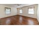 Spacious bedroom with hardwood floors, three windows, and a ceiling fan at 1706 Carthage St, Sanford, NC 27330