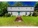 Two-story home featuring light gray siding and a brick walkway leading to a teal-colored front door at 1706 Carthage St, Sanford, NC 27330