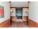 Foyer with brick flooring, wood wainscoting, and decorative sconces on the white walls at 1706 Carthage St, Sanford, NC 27330