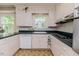 Bright kitchen with white cabinets, vintage appliances, and a view of the garden from multiple windows at 1706 Carthage St, Sanford, NC 27330