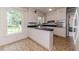 Well-lit kitchen featuring white cabinets, a breakfast bar, and a tiled floor for classic appeal at 1706 Carthage St, Sanford, NC 27330