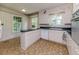 Classic kitchen with white cabinets, floral wallpaper, and tiled floors at 1706 Carthage St, Sanford, NC 27330