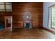 Inviting living room showcasing a fireplace, hardwood floors, and wood paneling at 1706 Carthage St, Sanford, NC 27330