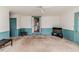 Living room with neutral carpet, wainscoting on the lower walls, and multiple doorways at 1706 Carthage St, Sanford, NC 27330