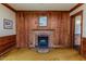 Cozy living room with wood-paneled walls, a brick fireplace, and classic architectural details at 1706 Carthage St, Sanford, NC 27330