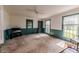 Living room with two windows, a bookcase, neutral carpet, and wainscoting on the walls at 1706 Carthage St, Sanford, NC 27330