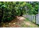 Serene pathway bordered by a rustic wooden fence and lush greenery, creating a tranquil outdoor experience at 1706 Carthage St, Sanford, NC 27330