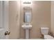 Clean, neutral half-bathroom features a pedestal sink, toilet, framed mirror, and modern fixtures at 1743 Longshadow Dr, Burlington, NC 27217