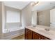 Well-lit bathroom featuring double sinks, a soaking tub, and a separate shower area at 1743 Longshadow Dr, Burlington, NC 27217