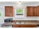 Close-up of a kitchen sink with stainless-steel appliances, laminate countertops, and wood cabinets at 1743 Longshadow Dr, Burlington, NC 27217