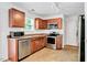 Functional kitchen features stainless steel appliances, wood cabinets, and tile floors at 1743 Longshadow Dr, Burlington, NC 27217