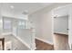 Bright hallway with wood floors, white railings, and views of the rooms and staircase at 201 Bog Hill Ln, Cary, NC 27519