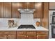 Wood kitchen cabinetry with stainless steel range hood and cooktop with white quartz countertops at 201 Bog Hill Ln, Cary, NC 27519