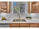 Close up of kitchen sink and window with view of nature, stainless steel sink and white subway tile backsplash at 201 Bog Hill Ln, Cary, NC 27519