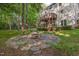 Backyard features a multi-level deck, stone patio, and fire pit, perfect for outdoor entertaining at 208 W Camden Forest Dr, Cary, NC 27518
