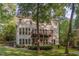 Exterior rear of the home with a wooden deck and a lush backyard and trees at 208 W Camden Forest Dr, Cary, NC 27518