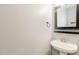 A half bathroom featuring a pedestal sink and a decorative mirror at 208 W Camden Forest Dr, Cary, NC 27518