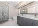 Bathroom with grey cabinets, marble countertop, dual sinks, a soaking tub and glass enclosed shower at 208 W Camden Forest Dr, Cary, NC 27518