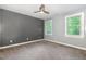 Bedroom with a ceiling fan, hardwood-style floors, neutral walls, and a large window at 208 W Camden Forest Dr, Cary, NC 27518