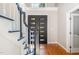 Bright foyer showcases a hardwood floor, staircase with black railing and glass-paneled front door at 208 W Camden Forest Dr, Cary, NC 27518