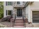 Inviting front entrance featuring a stone facade, brick steps, and a modern glass-paneled door at 208 W Camden Forest Dr, Cary, NC 27518
