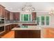 Modern kitchen with stainless steel appliances, granite countertops, island with cooktop, and mosaic backsplash at 208 W Camden Forest Dr, Cary, NC 27518