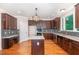 Modern kitchen featuring stainless steel appliances, dark wood cabinets, and granite countertops at 208 W Camden Forest Dr, Cary, NC 27518