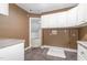 Laundry room with tile flooring, white cabinets, and utility sink with washer and dryer hookups at 208 W Camden Forest Dr, Cary, NC 27518