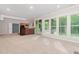 A carpeted living room with a kitchen and windows offering a beautiful view at 208 W Camden Forest Dr, Cary, NC 27518