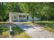 View of the house, showing the driveway and front yard surrounded by mature trees at 2108 Laurel Mill Centerville Rd, Louisburg, NC 27549