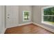 Room with laminate floors, two windows providing plenty of natural light, and front door at 2108 Laurel Mill Centerville Rd, Louisburg, NC 27549