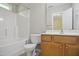 Bright bathroom featuring a shower-tub combo, wooden vanity, and toilet at 2207 Bankshill Row, Raleigh, NC 27614