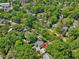 Aerial view of a home nestled among lush trees, with a nearby street and surrounding residences at 224 E Park Dr, Raleigh, NC 27605