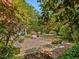 Backyard features a brick patio, lush garden, stone bench, and dining furniture at 224 E Park Dr, Raleigh, NC 27605