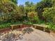 Charming brick patio featuring lush plantings, stone benches, and water feature at 224 E Park Dr, Raleigh, NC 27605