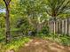 Backyard with a cozy bench in a natural setting, complemented by a wooden fence and lush greenery at 224 E Park Dr, Raleigh, NC 27605