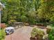 Brick patio with an outdoor table and chairs in a beautifully landscaped yard at 224 E Park Dr, Raleigh, NC 27605