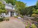 Brick patio with table and chairs in a landscaped backyard with white siding at 224 E Park Dr, Raleigh, NC 27605