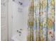 Bathroom with shower featuring patterned shower curtain, fixtures, and white tiled walls at 224 E Park Dr, Raleigh, NC 27605