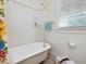 Bright bathroom featuring a clawfoot tub with gold fixtures and a floral shower curtain at 224 E Park Dr, Raleigh, NC 27605